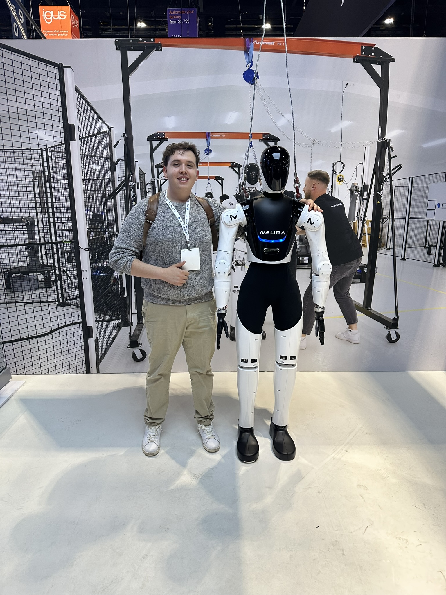Standing with a humanoid robot at a robotics event.